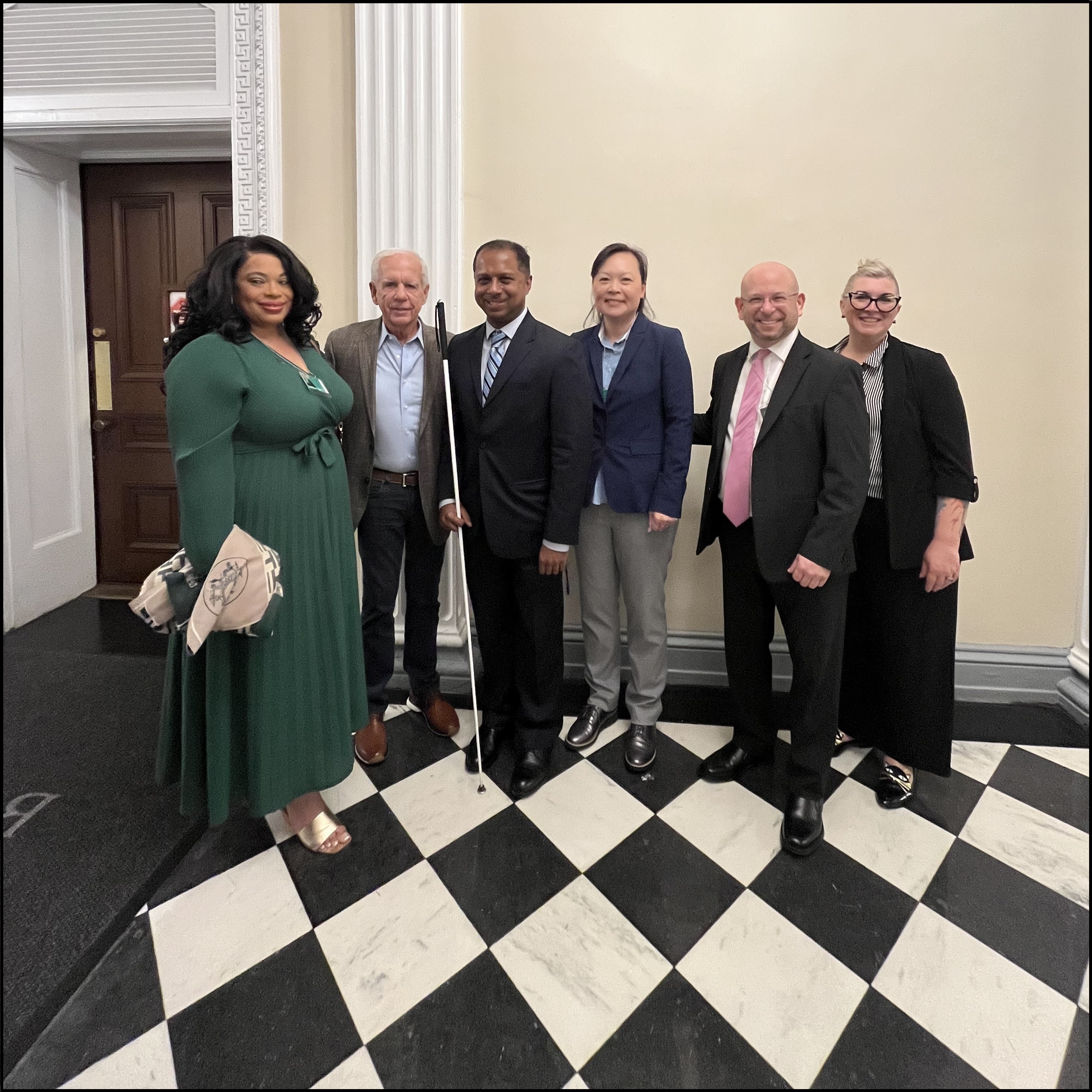 Six people stand in a row, including Bernice Martin Lee, Tony Coelho, and Howard Rosenblum, along with Access Board staff members Sachin Pavithran, Kathy Eng, and Amy Nieves.